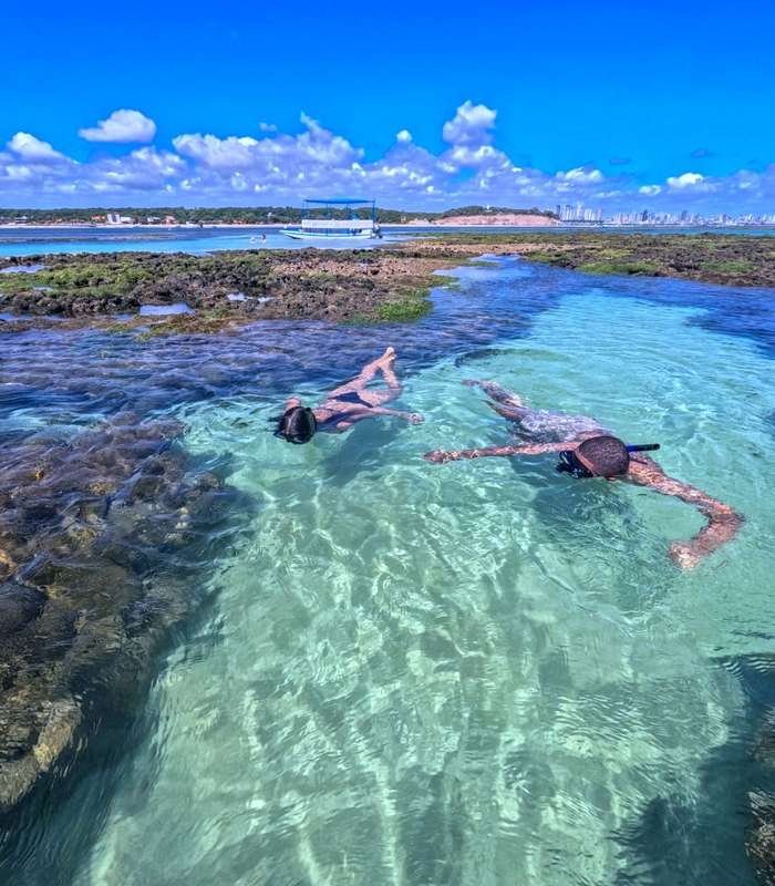 Duas pessoas fazendo snorkel nas Piscinas Naturais do Seixas